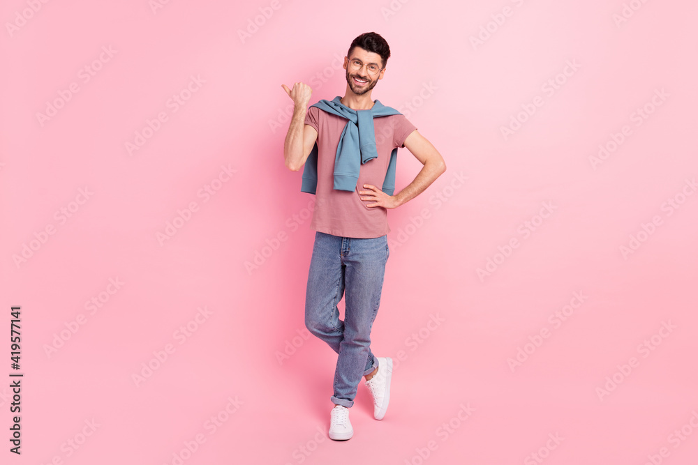 Full length photo of charming young man point finger empty space advert choose isolated on pink color background Full length photo of charming young man point finger empty space advert choose isolated on pink color background