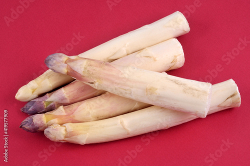 Asperges blanches en gros plan sur fond rouge photo