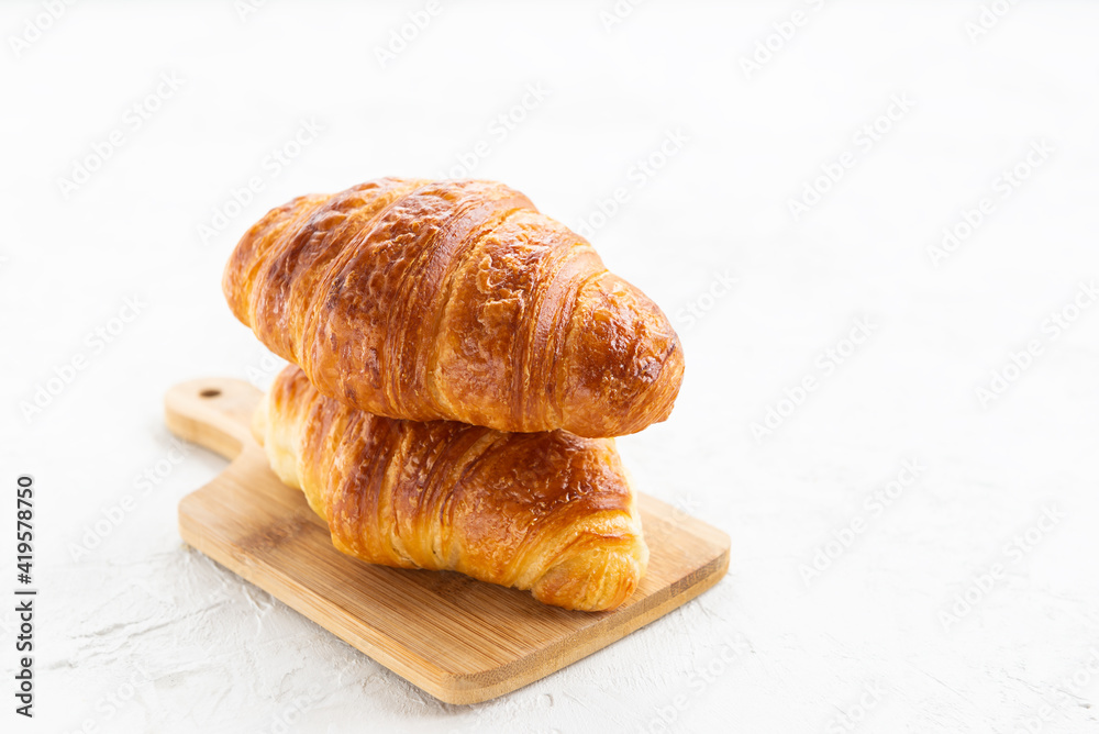 Fresh French croissants on a wooden board. Fresh French croissants on a wooden board.