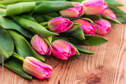 Women s Day. Pink tulips bouquet on wooden planks background  copy space  top view. Spring flowers
