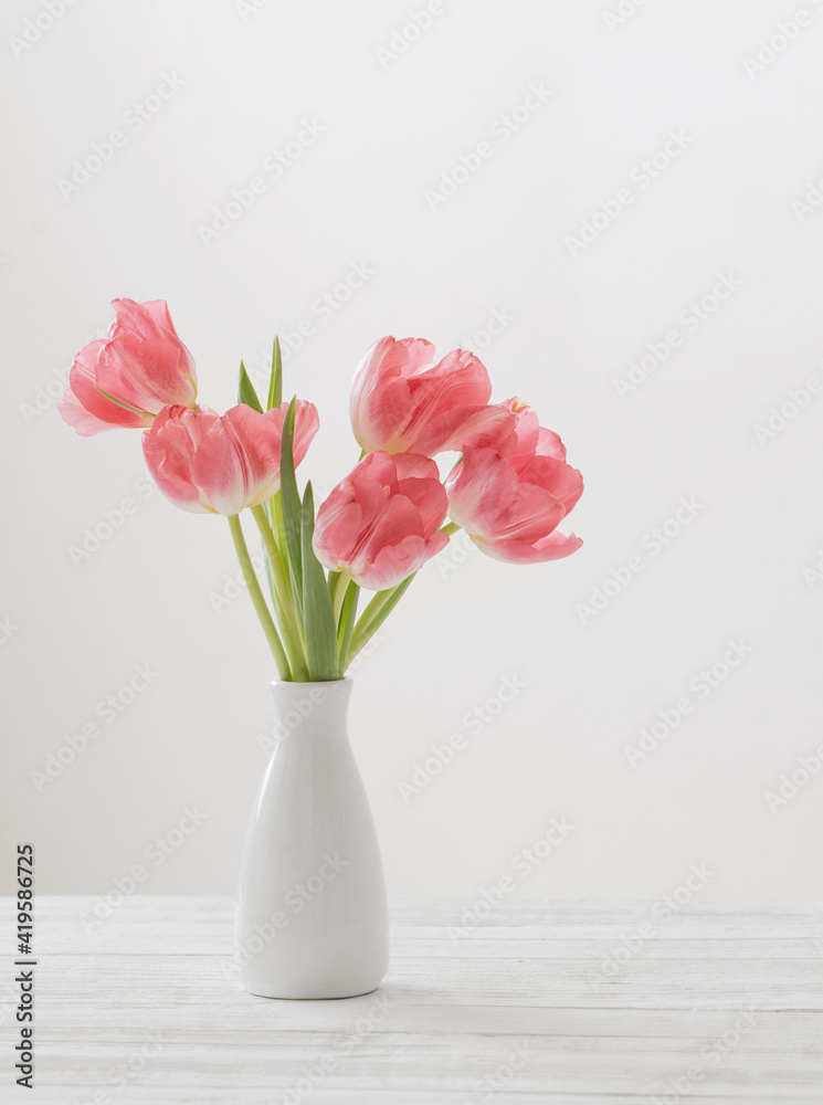 spring tulips in white vase on white background