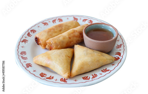close up of Asian snack food or finger food for starter with Lumpias or spring rolls and samozas served with sweet chilli sauce, isolated on white background with clipping path.