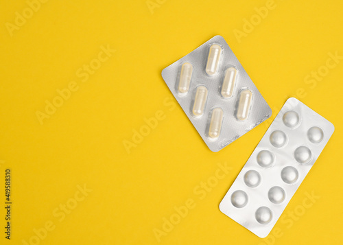 round pills in blister packs on a yellow background