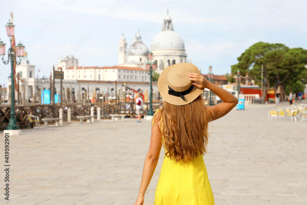 Tourism in Venice, Italy. Young traveler girl on summer holidays in Europe. Female back view with Venice landscape on the background.