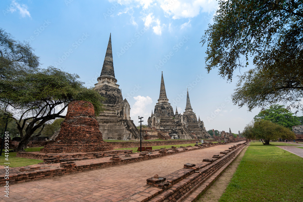Fototapeta premium three ancient pagodas (chedies) ruins of old Siam capital Ayutthaya at Wat Phra Si Sanphet temple and walk way, famous place for travelling in Phra Nakhon Si Ayutthaya Province, Thailand 
