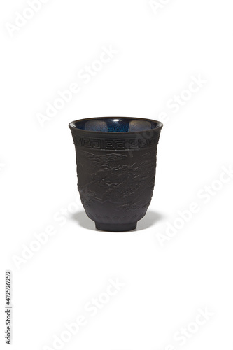 Subject shot of classic Chinese cup decorated with dragon embossing and blue tianmu pattern. Brown fancy cup for tea ceremony is isolated on the white background. photo