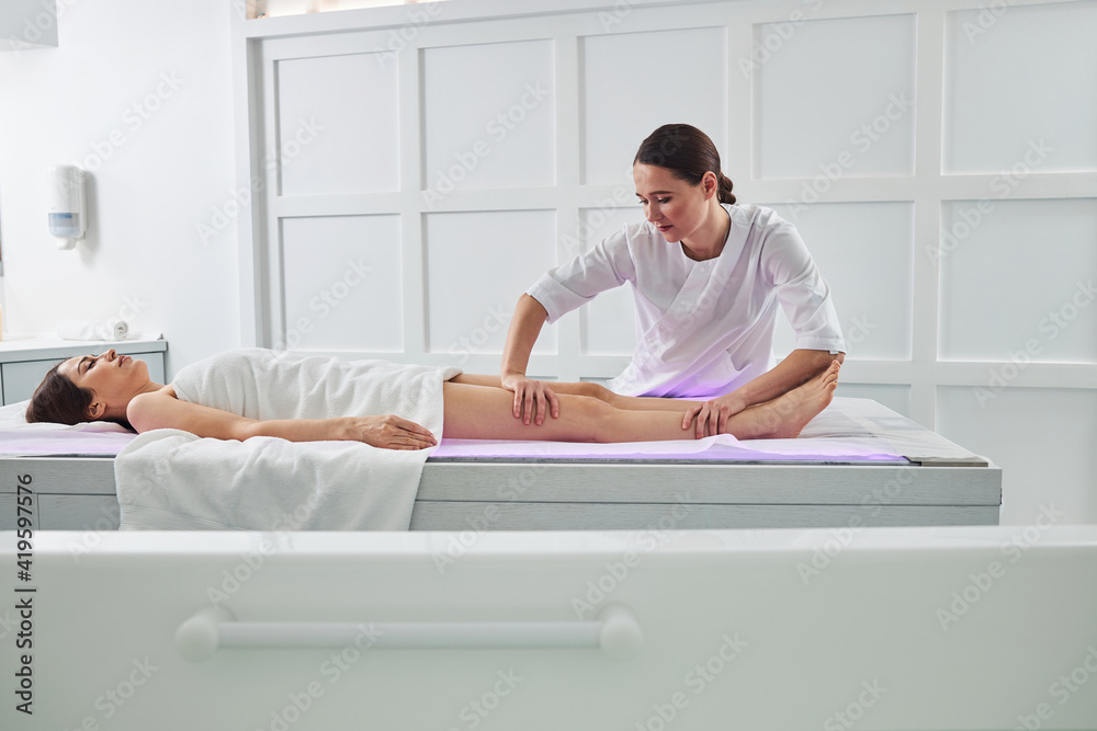 Charming woman receiving professional massage in spa salon Charming woman receiving professional massage in spa salon