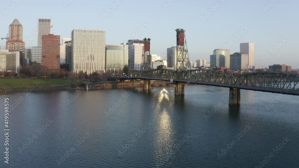 Aerial Forward: Large Truss Bridge Leads To Major City With Skyscrapers And Office Buildings In Sunshine Aerial Forward: Large Truss Bridge Leads To Major City With Skyscrapers And Office Buildings In Sunshine