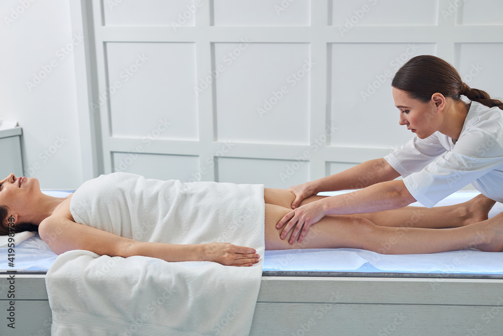 Nice woman receiving professional massage in beauty salon Nice woman receiving professional massage in beauty salon