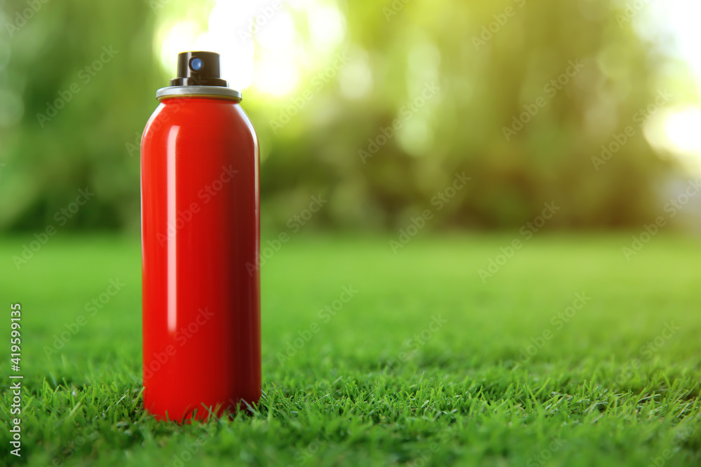 Bottle of insect repellent spray on green grass. Space for text Bottle of insect repellent spray on green grass. Space for text