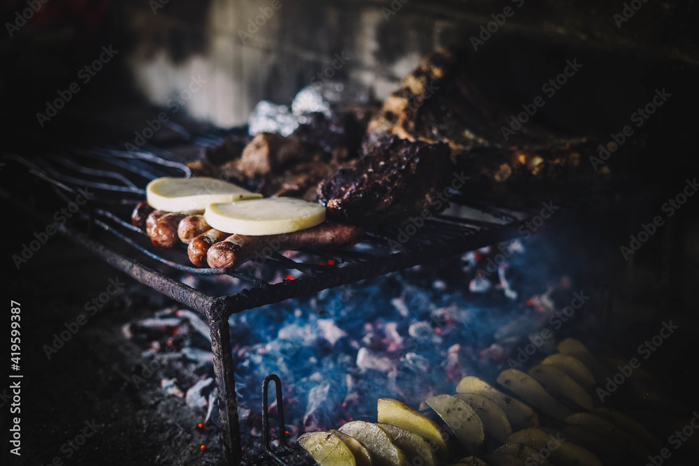 Tipico asado argentino con carne y patatas hecho a las brasas