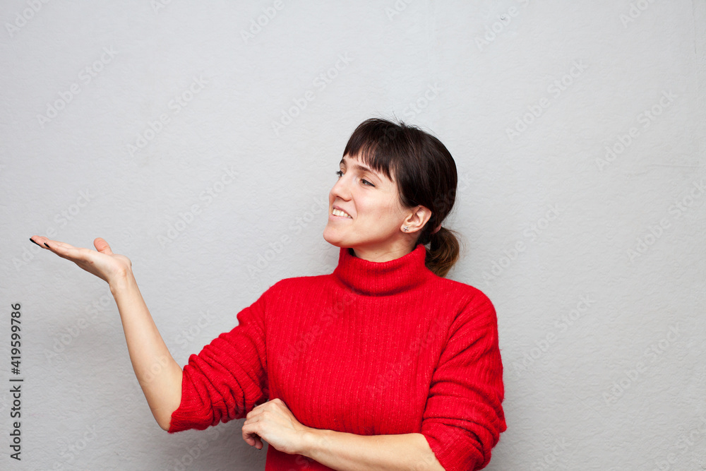 Woman in red sweater points to side Woman in red sweater points to side