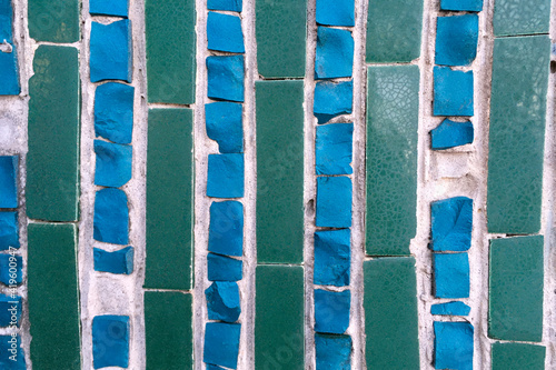 Blue-green abstract tile mosaic wall or floor as decorative background. Soft focus. Close-up.