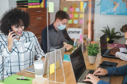 Young business team with face masks inside modern office working during coronavirus outbreak - Focus on woman face