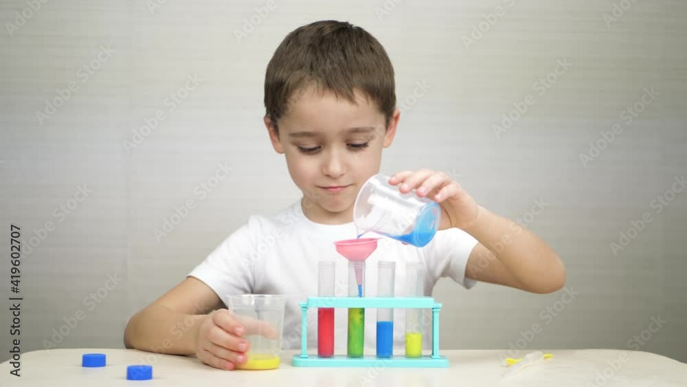 Happy child playing. Kids doing a chemical experiment in laboratory at school. Children laboratory Happy child playing. Kids doing a chemical experiment in laboratory at school. Children laboratory