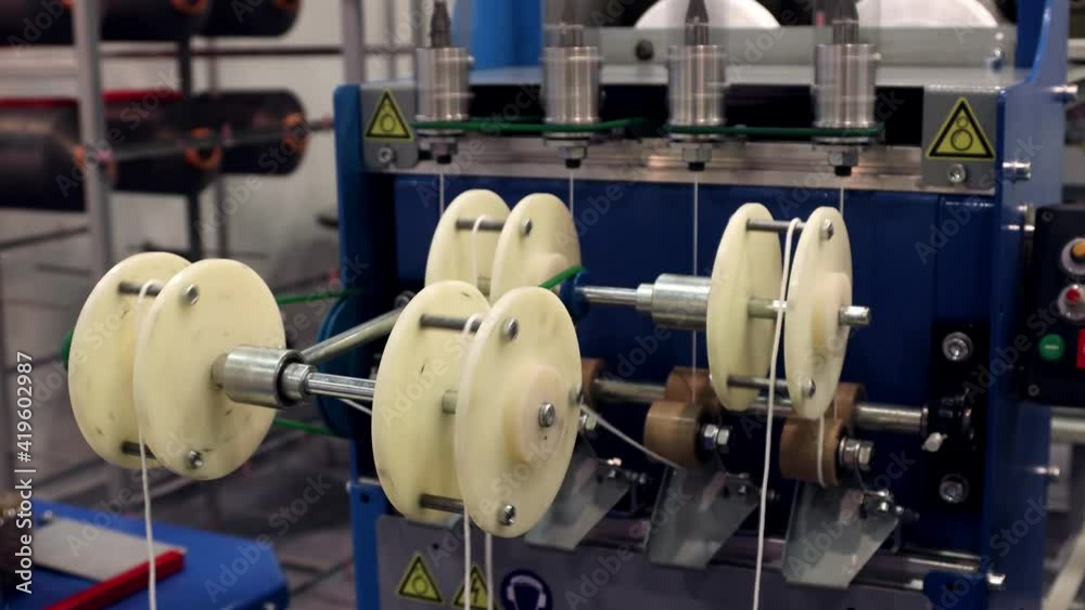 bobbins with white threads on the shelves of a clothing factory bobbins with white threads on the shelves of a clothing factory