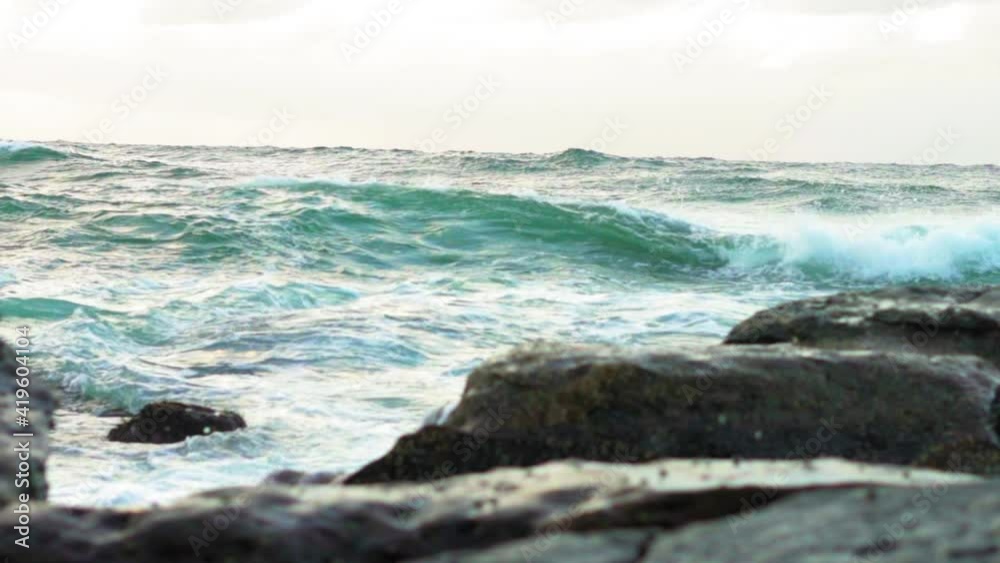 Slow Motion Tilt Down: Waves Splashing On Rock Formations In Sea Slow Motion Tilt Down: Waves Splashing On Rock Formations In Sea
