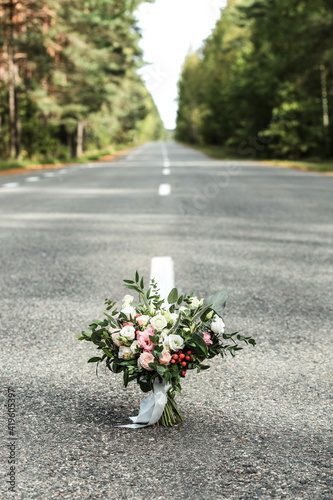 wedding bouquet stands in the middle of the road in the forest