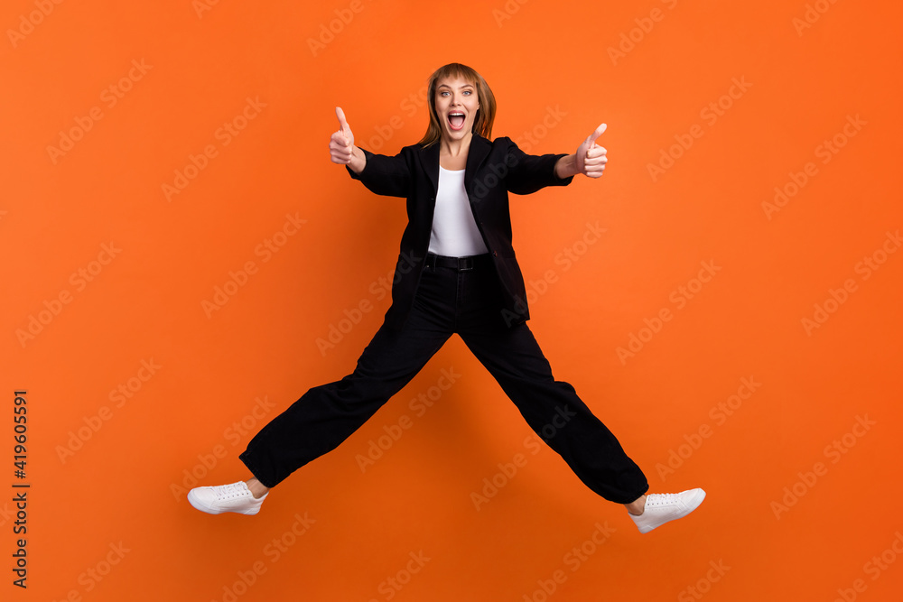 Full size photo of happy excited crazy good mood funky girl jumping showing you thumb-up isolated on orange color background
