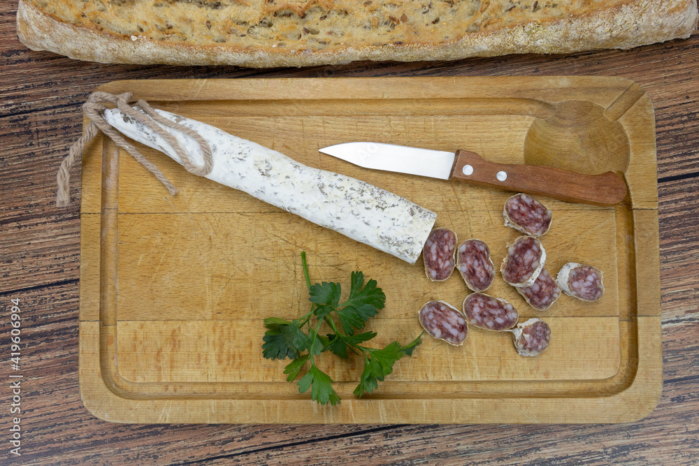 saucisson sec en tranches sur une planche à découper	
