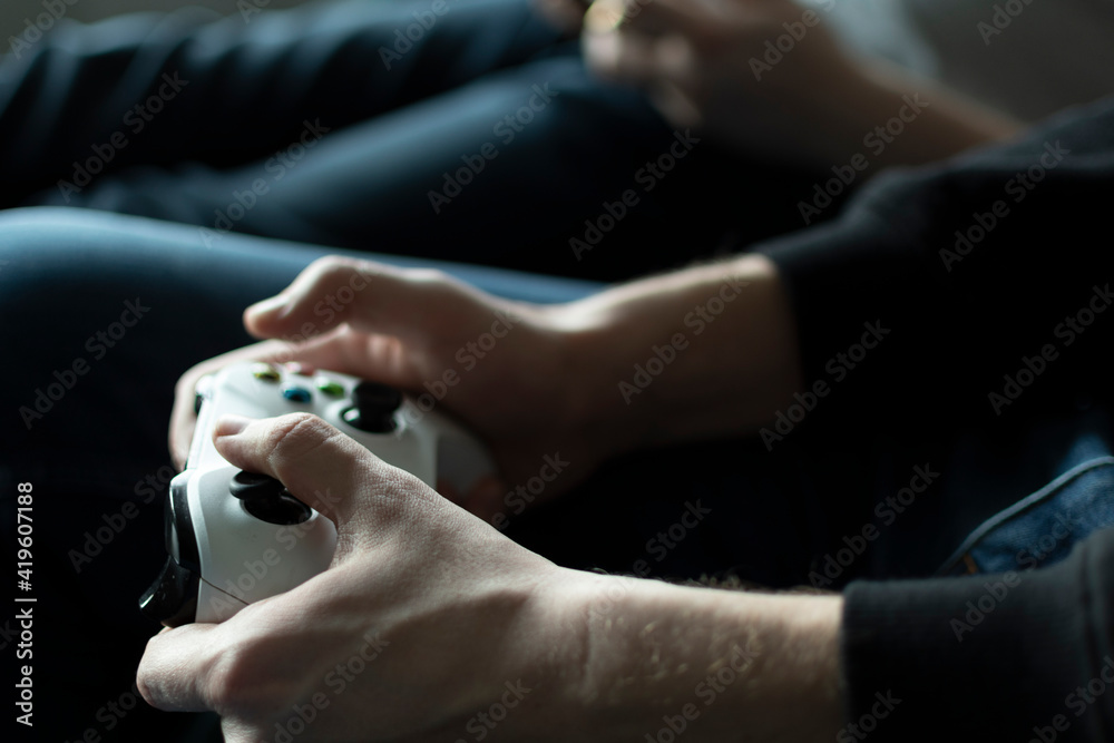 Two friends hold a joystick in their hands and play a computer game Two friends hold a joystick in their hands and play a computer game