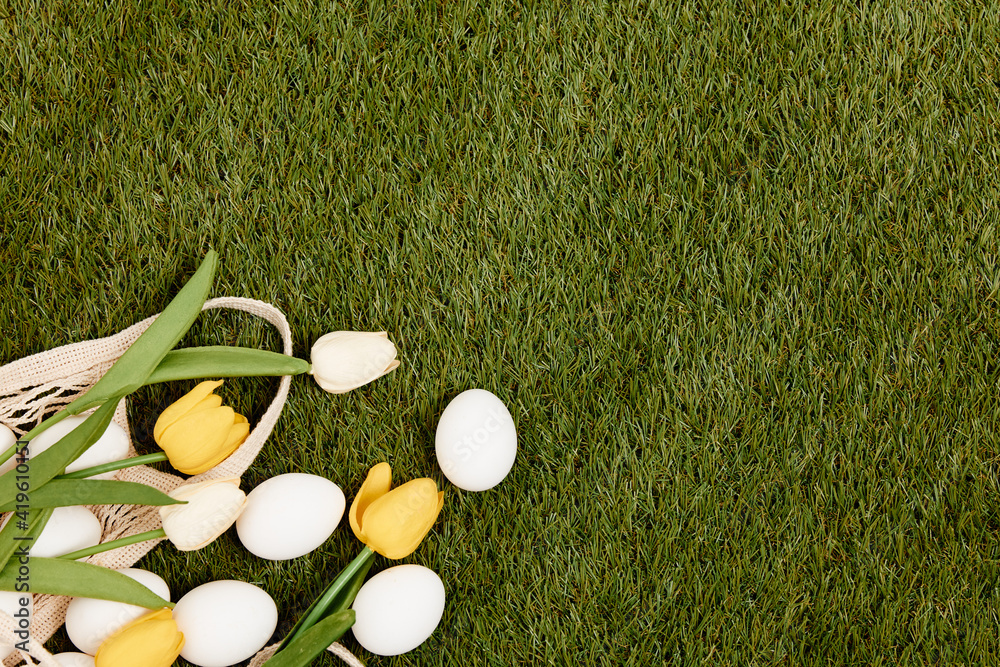 Naklejka premium Easter eggs lie on green grass Copy Space decoration