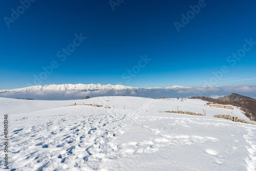 Mountain range of the Monte Baldo, Adamello and Brenta Dolomites in winter with snow, view from the Lessinia Plateau (Altopiano della Lessinia) Verona. Veneto and Trentino Alto Adige, Italy, Europe.