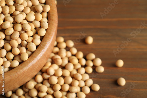 Bowl with soy on wooden table, closeup. Space for text