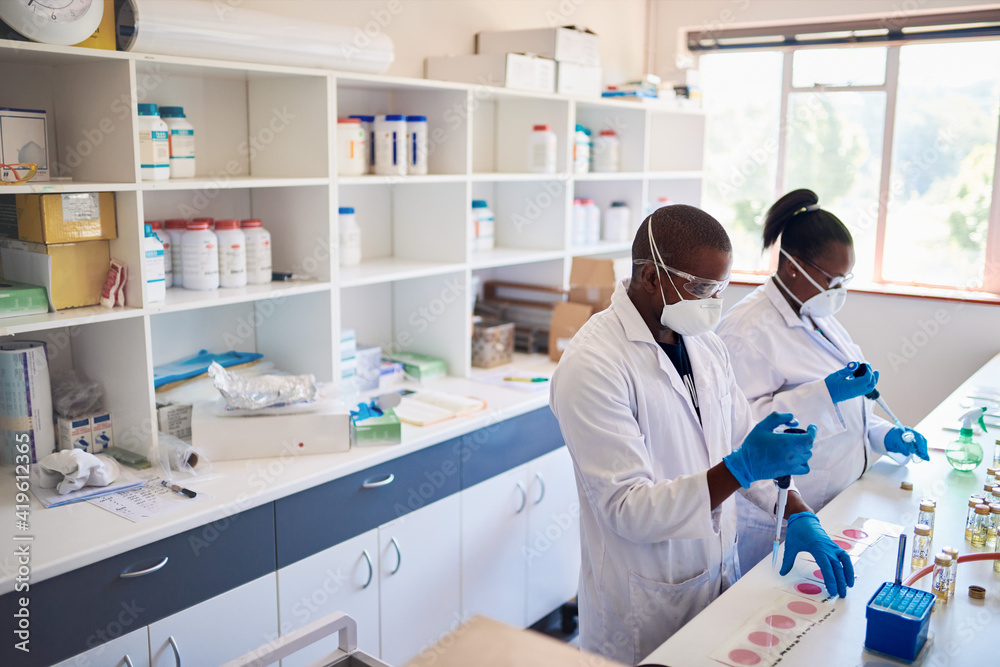 African lab technicians preparing samples using pipettes