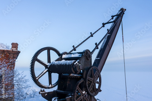 An old metal crane at the pier of the fourth northern fort of Zverev. Kronstadt fortress. Island of forts. The Gulf of Finland. photo