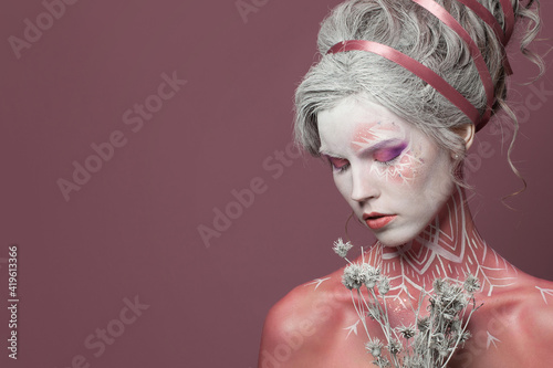 Pretty winter woman fashion model with creatuve makeup on pink background photo