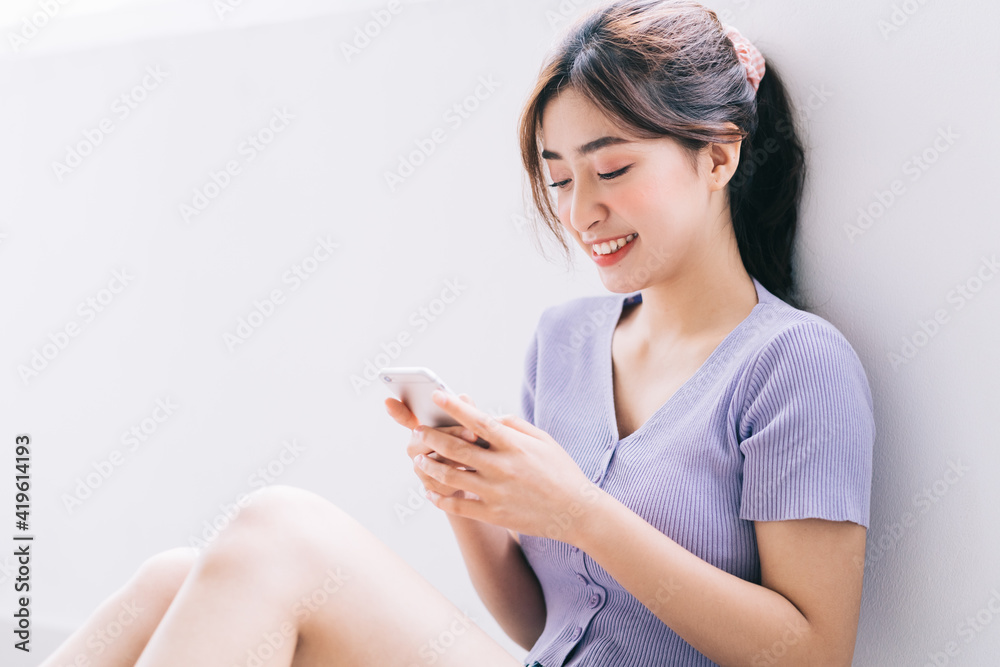 Beautiful young Asian woman using smartphone at home Beautiful young Asian woman using smartphone at home