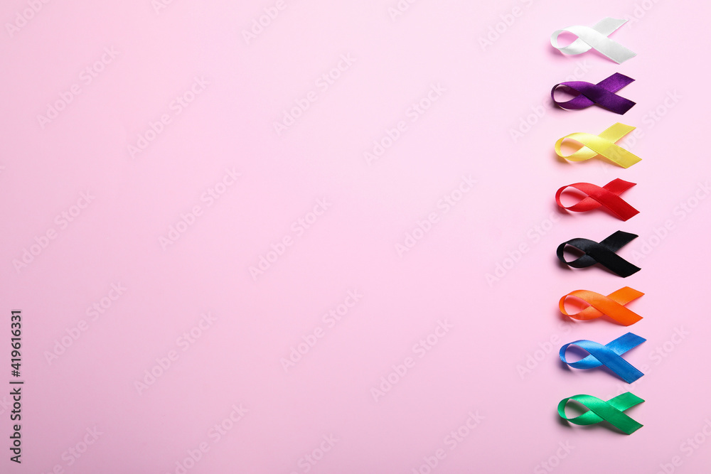 Colorful ribbons on pink background, flat lay with space for text. World Cancer Day Colorful ribbons on pink background, flat lay with space for text. World Cancer Day
