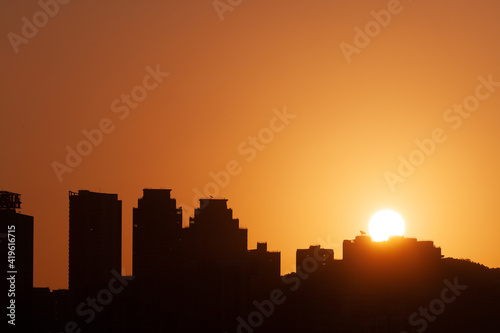 Sunrising behind a silhouette of a skyline