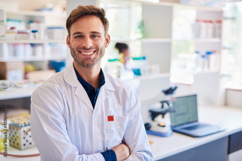 Smiling young male technician working in a lab Smiling young male technician working in a lab