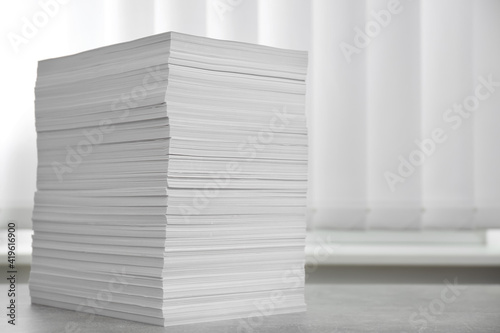 Stack of paper sheets on grey table. Space for text