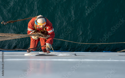 Foto Seaman ship crew working aloft at height derusting and getting vessel ready for painting