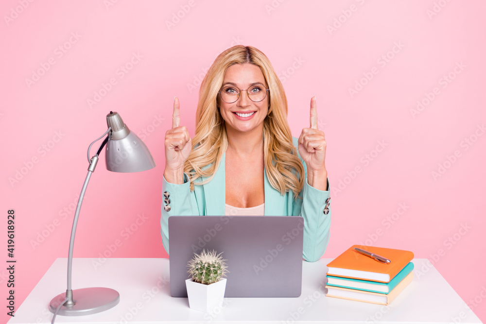 Photo of young happy positive businesswoman point finger copyspace advertise isolated on pink color background
