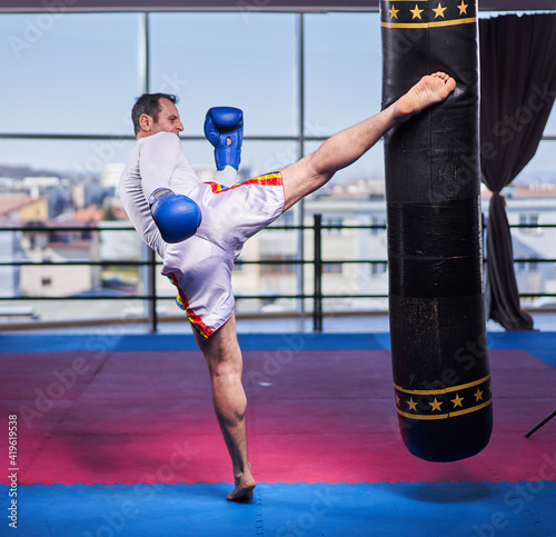 Kickboxer hitting the heavy bag in the gym © Xalanx