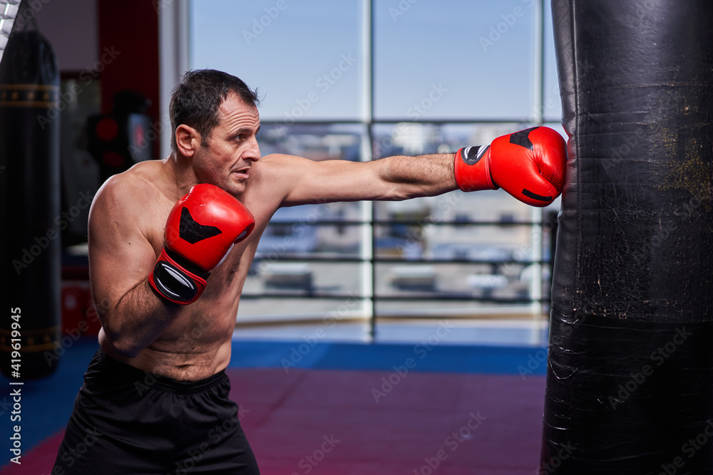 Kickboxer hitting the heavy bag in the gym