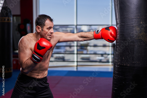 Kickboxer hitting the heavy bag in the gym