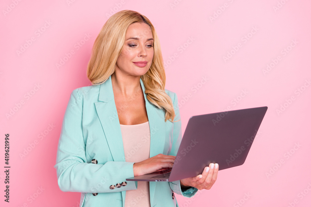 Photo of young happy good mood businesswoman typing working in laptop isolated on pink color background