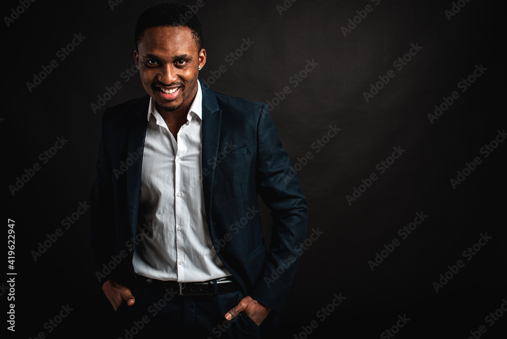 portrait of attractive, beautiful, serious and stylish professional African American businesswoman in dark suit and white shirt isolated on dark background. Low key. Selective focus	