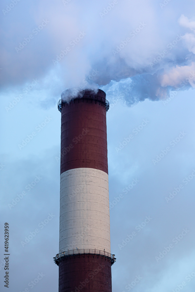 A industrial chimney in the clouds of steam. Sunny winter day. A industrial chimney in the clouds of steam. Sunny winter day.