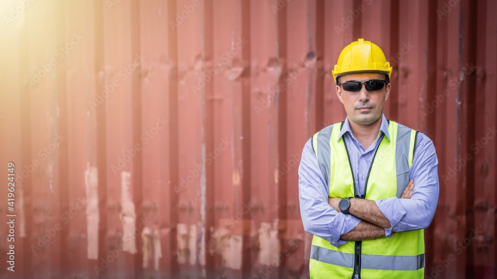 Confident Middle-eastern male engineer portrait in uniform standing in front of the container. Logistics and shipping. Professional occupation. Confident Middle-eastern male engineer portrait in uniform standing in front of the container. Logistics and shipping. Professional occupation.
