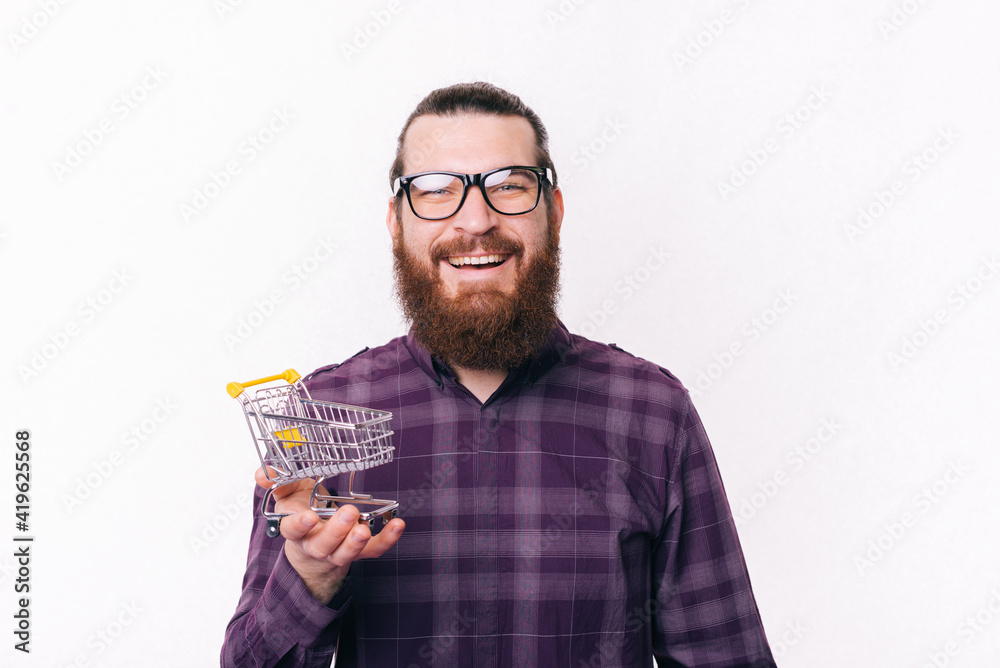 Photo of happy young man holding small shopping trolley Photo of happy young man holding small shopping trolley