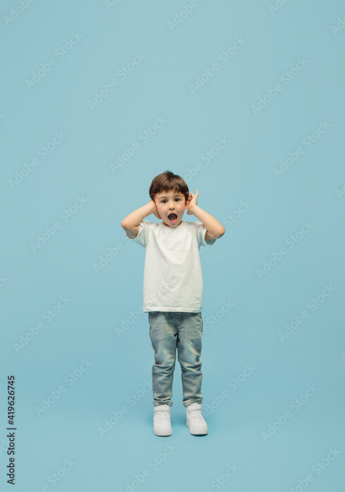 Shouting, screaming. Happy, smiley little caucasian boy isolated on blue studio background with copyspace for ad. Looks happy, cheerful. Childhood, education, human emotions, facial expression concept Shouting, screaming. Happy, smiley little caucasian boy isolated on blue studio background with copyspace for ad. Looks happy, cheerful. Childhood, education, human emotions, facial expression concept