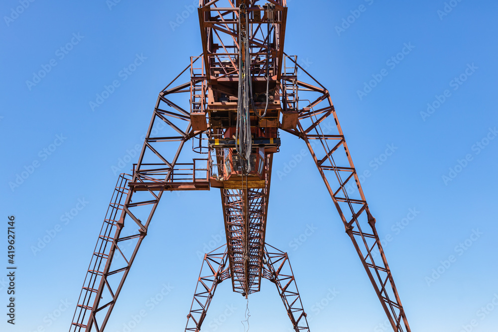 Industrial crane, lift, forklift a sawmill outdoors. Timber loading Gantry crane. Industrial crane, lift, forklift a sawmill outdoors. Timber loading Gantry crane.