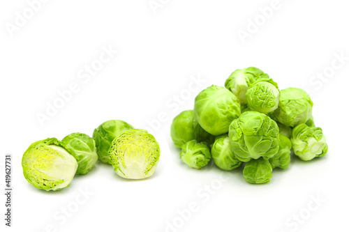 Fresh organic brussels sprouts in heap, whole and halves, isolated on white background.	