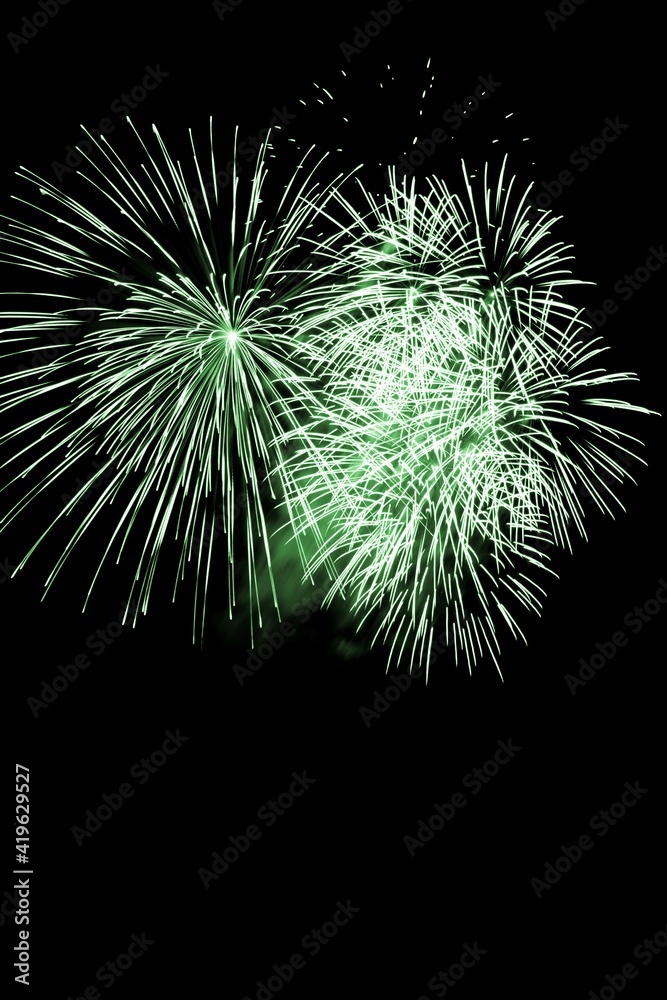 Luxury fireworks event sky show with green big bang stars. Premium entertainment magic star firework at e.g. New Years Eve or Independence Day party celebration. Black dark night background Luxury fireworks event sky show with green big bang stars. Premium entertainment magic star firework at e.g. New Years Eve or Independence Day party celebration. Black dark night background
